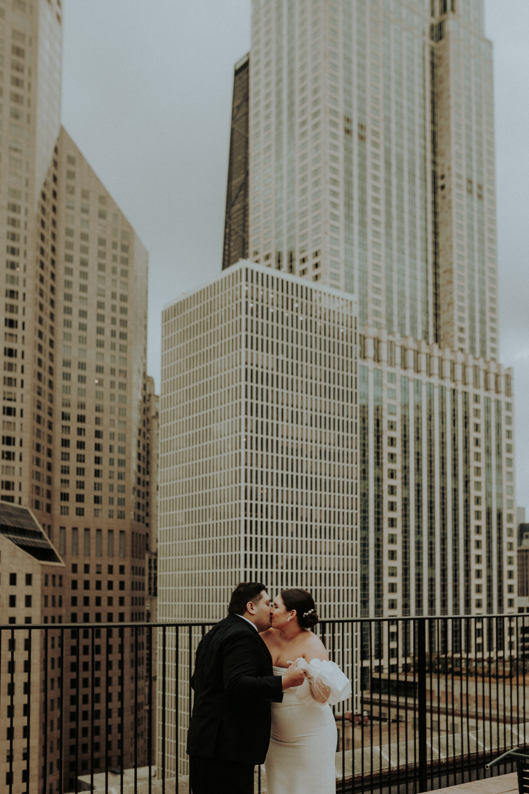 Abby and Carlos embrace under the marquee lights of Lux Bar in downtown Chicago during their romantic elopement.