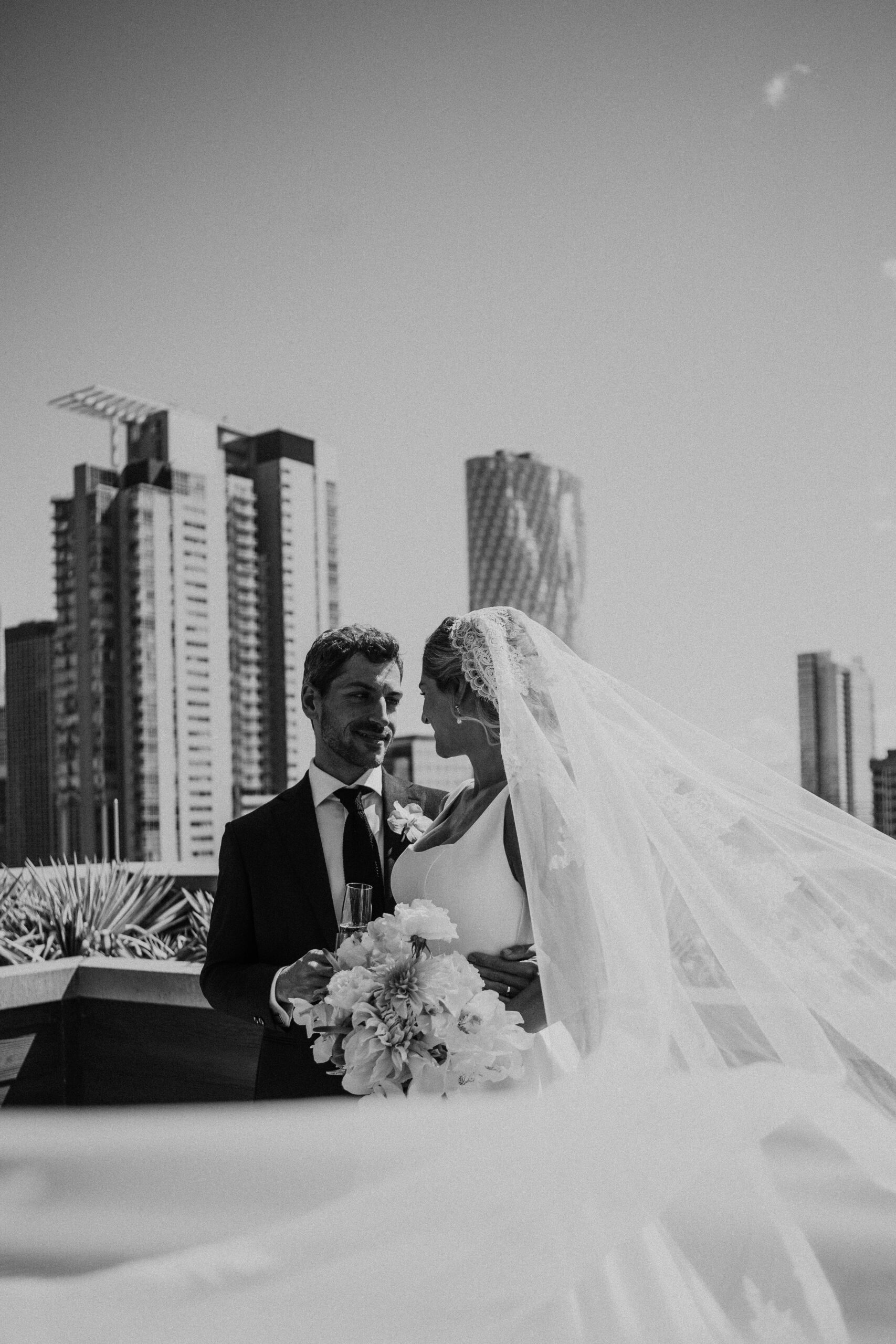 Joey and Schuyler sharing a joyful embrace on the rooftop deck of Celeste Chicago, surrounded by family and friends.