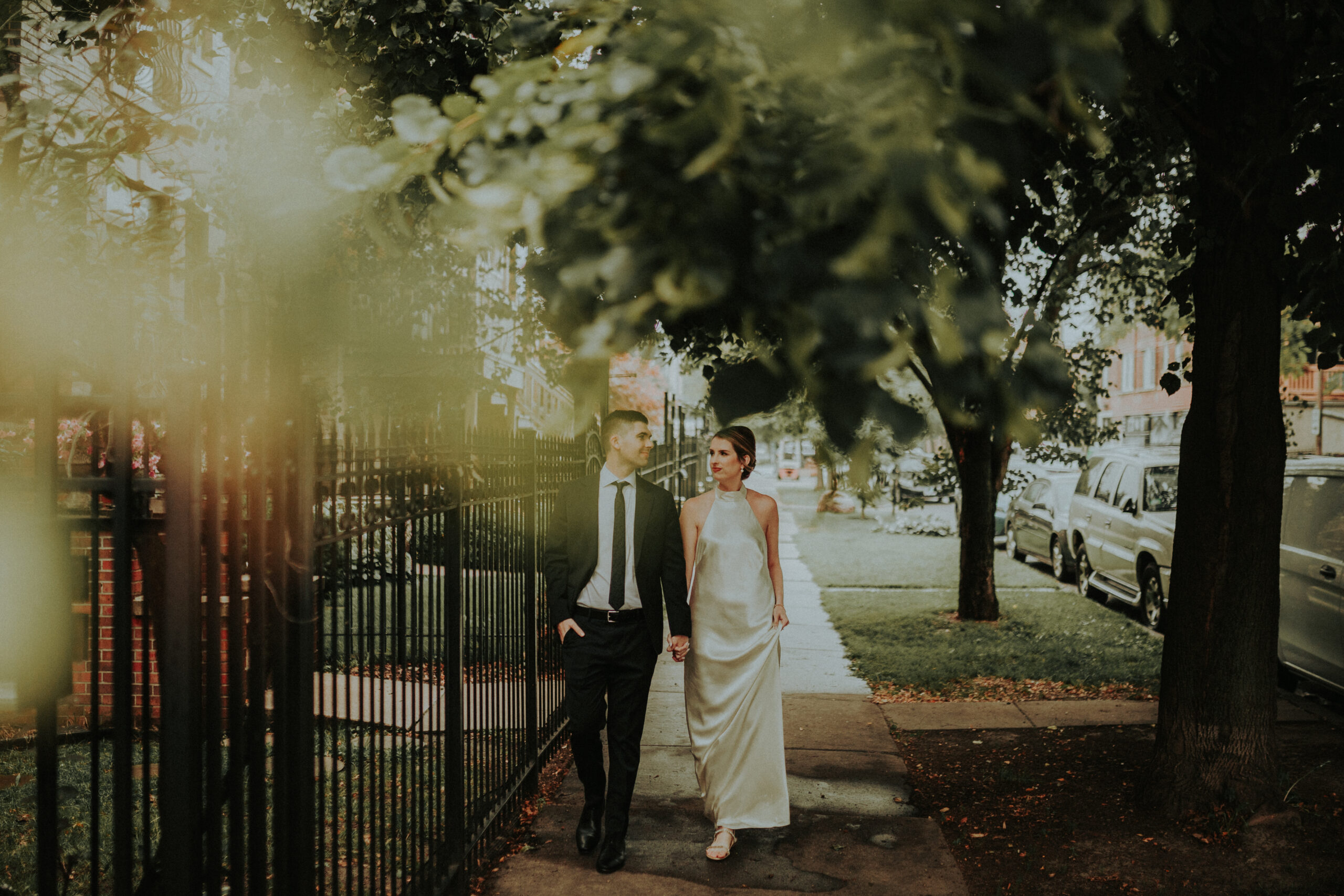 Katie and Eric embrace during their intimate Hyde Park elopement in Chicago, standing against a backdrop of their warm and inviting home.